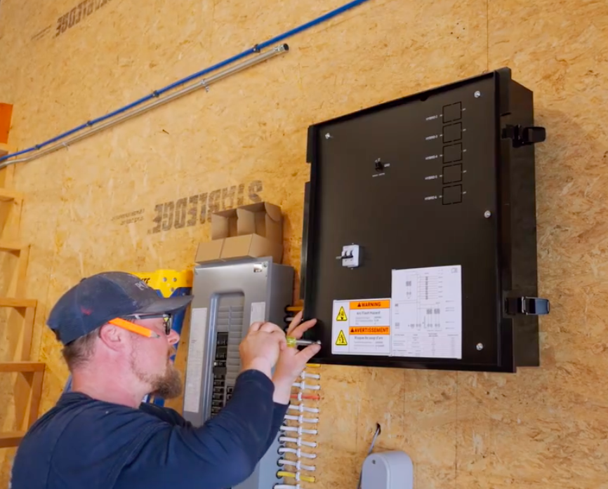 Electrician installing EV charger in workshop, featuring black charger unit and electrical panel, emphasizing professional electrical services for home and business.