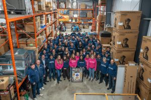 The Postma Heating & Cooling team standing together in their warehouse, celebrating over 35 years of trusted HVAC service in Chatham, Ontario.