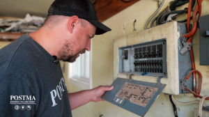 Postma HVAC technician checking home electrical panel in Chatham-Kent to troubleshoot thermostat acting up and HVAC power issues.