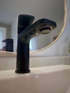 Hard water mineral buildup on a bathroom faucet caused by calcium deposits in Chatham-Kent homes.