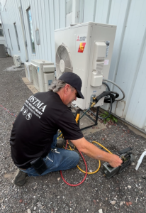 Technician charging heat pump with refrigerant during HVAC service in Chatham-Kent Ontario