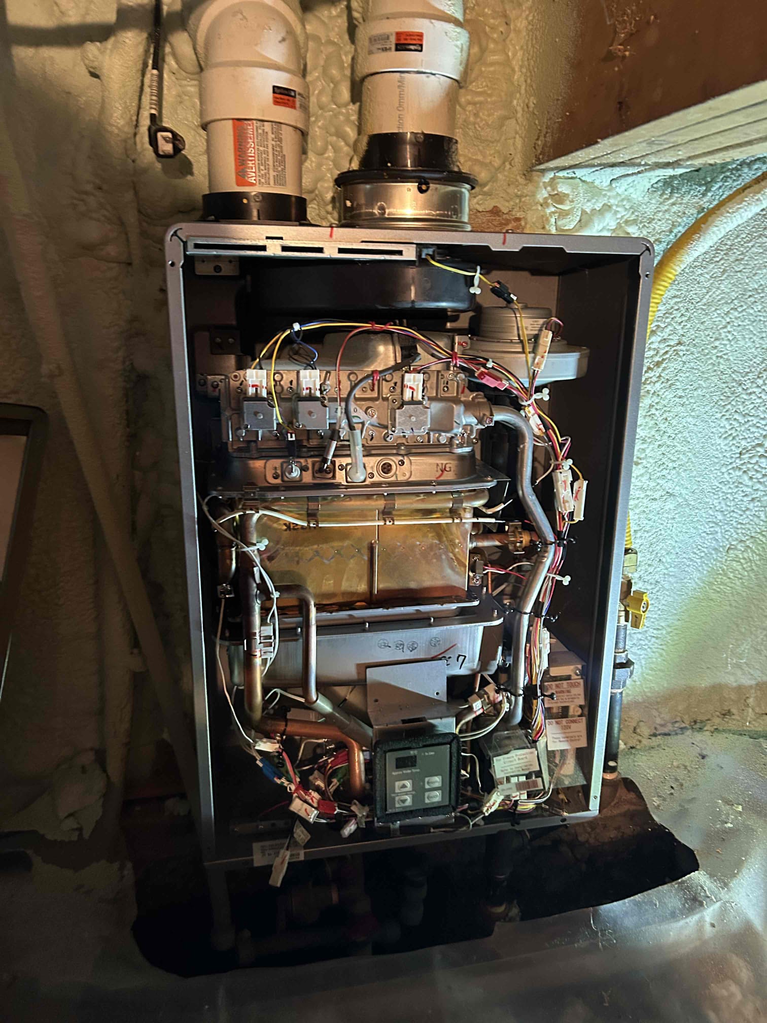 Open furnace during a fall furnace inspection in Chatham-Kent, showing internal components being checked by a technician.